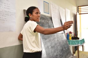 Teacher standing at blackboard in Timor-Leste