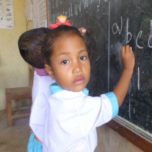 Young Girl with Flower in hair at Blackboard