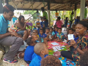 Teacher with children in outdoor early primary classroom